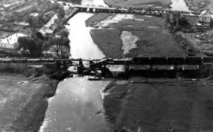 Zniszczony most kolejowy w Łowiczu w trakcie odbudowy. Wycofujące się Wojsko Polskie zniszczyło za sobą niektóre mosty na Bzurze, w tym most drogowy i kolejowy w Łowiczu (w tle, prowizorycznie odbudowany).