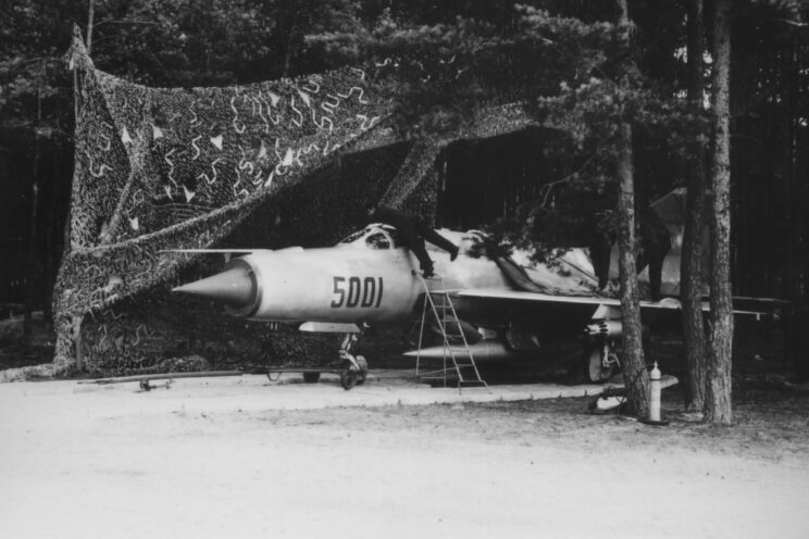 Przykład maskowania samolotu myśliwskiego MiG-21PFM na prowizorycznym wjeździe z drogowego odcinka lotniskowego do lasu.
