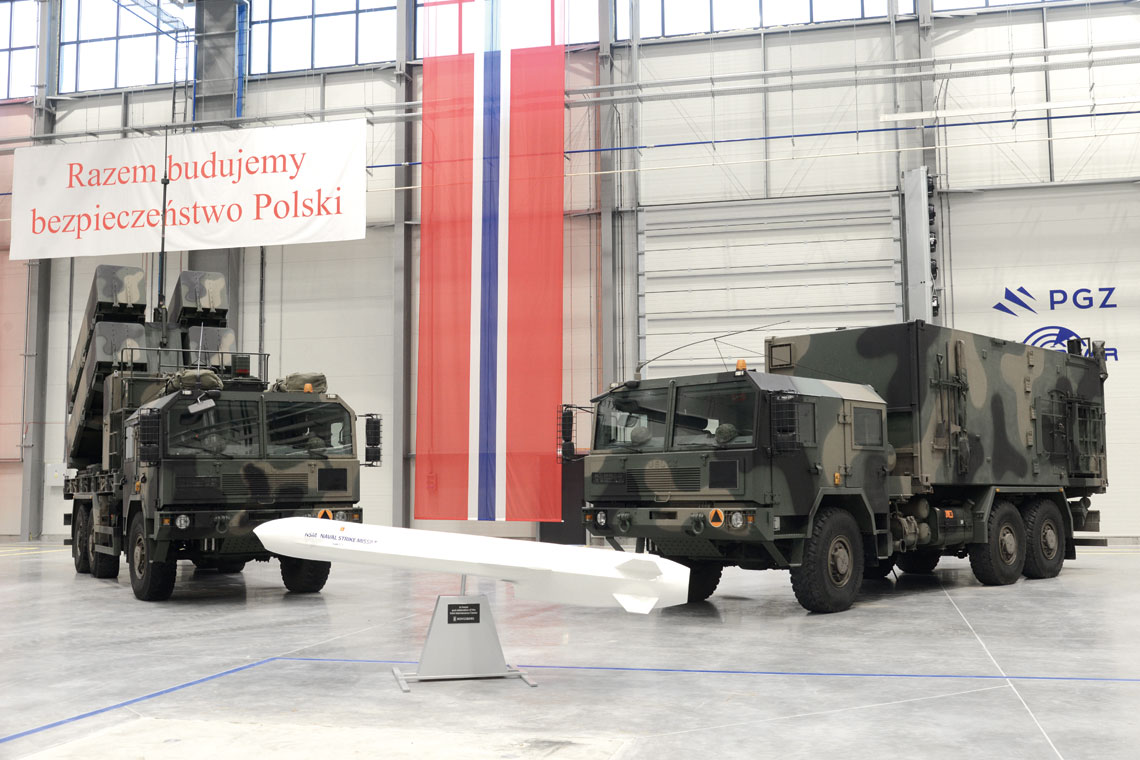 26 października, należące do Polskiej Grupy Zbrojeniowej, spółki PIT-RADWAR S.A. i Wojskowe Zakłady Elektroniczne S.A. podpisały umowy podwykonawcze z Kongsberg Defence & Aerospace AS na wykonanie i dostawy elementów dwóch Morskich Jednostek Rakietowych oraz serwisowanie i produkcję pocisków kierowanych NSM. Scenerię uroczystości tworzyły: wyrzutnia MLV (Missile Launch Vehicle, po lewej), makieta pocisku kierowanego NSM i wóz kierowania uzbrojeniem CCV (Command Control Vehicle). 
